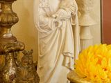 une statue de Jésus et un vase de fleurs posés sur une table