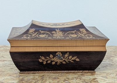 a wooden box with a design on it sitting on a table