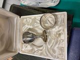 a silver spoon and two glasses in a box
