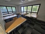 de nombreuses tables et chaises dans une pièce dotée de grandes fenêtres