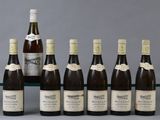 several bottles of wine are lined up on a glass shelf
