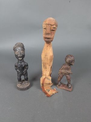 trois figurines en bois de formes et de tailles différentes posées sur une surface grise