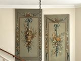 two paintings hanging on the wall above the stairs