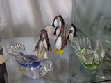a glass display case with glass penguins on it