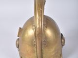 a gold helmet that is sitting on a white surface