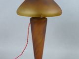 une image représentant une lampe posée sur une table, avec un cordon rouge