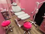 une pièce rose avec une chaise et des tabourets à l'intérieur