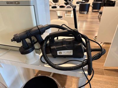 un sèche-cheveux noir posé sur une étagère blanche