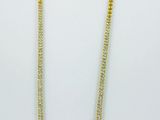 un collier à chaîne en or orné de deux rangées de perles sur fond blanc