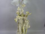 une statue représentant une femme et un homme tenant une lampe