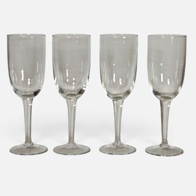 three empty wine glasses sitting next to each other on a white surface