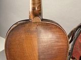 a violin that is sitting next to a red chair