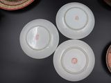 several plates and bowls are arranged on a table with a vase