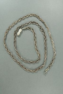 une image représentant une chaîne en argent avec un fermoir en argent sur un fond gris