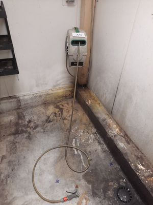 une photo d'une salle de bains sale dans laquelle se trouve un tuyau d'arrosage
