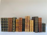 une rangée de vieux livres posés sur une table blanche