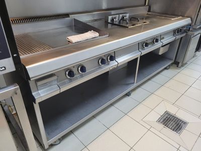 une cuisine équipée d'appareils électroménagers en acier inoxydable et d'un évier