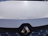 the front end of a white car with a black grille