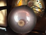 a close up of a clock with a metal ball on it