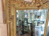 a large gold mirror sitting on the floor in a room