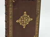 an old book with a golden cross on the front cover