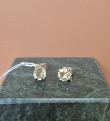 une paire de boucles d'oreilles en diamant posée sur un bloc de marbre
