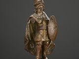 a bronze statue of a man with a shield and shield