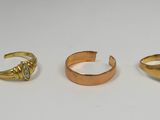 trois bagues en or et une bague sertie d'une pierre noire