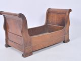 a wooden sleigh that is sitting on a white surface