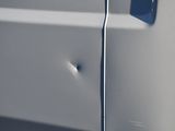 a close up of a car door with a bullet hole in it