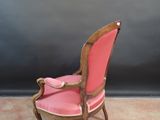 a pink chair that is sitting in a room