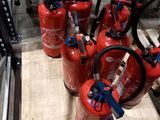 several fire extinguisors are lined up on a pallet in a warehouse