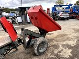 a red dump truck parked in a lot with other trucks in the background