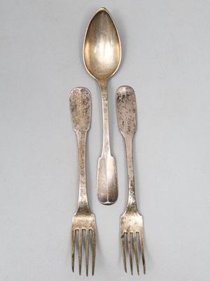 trois cuillères en argent et deux cuillères en argent sur une table