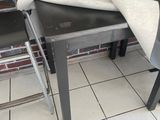 plusieurs chaises et une table dans une pièce aux murs en briques