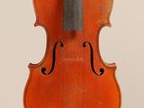 un vieux violon posé sur une surface blanche