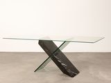 une table en verre avec un piètement en marbre noir et blanc