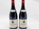 deux bouteilles de vin rouge posées l'une à côté de l'autre sur une surface blanche