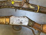 two old guns are sitting on top of a metal table
