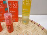 bottles of sunscreen lotion sitting on top of a bamboo tray