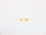 une bague en or sertie d'une perle, posée sur un fond blanc