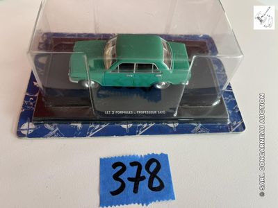une petite voiture verte dans une boîte transparente sur laquelle est apposée une étiquette de prix