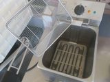 a person holding a fryer with a basket in it