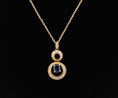 a gold necklace with a sapphire and diamond pendant