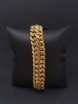 a gold rope bracelet on a black pillow