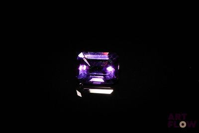 un diamant violet dans l'obscurité, éclairé par une lumière