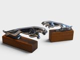 pair of silver jaguars on wooden bases on a white background