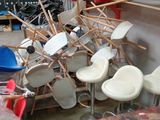many chairs and stools that are stacked up in a room