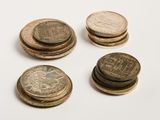 several coins are stacked on top of each other on a white surface