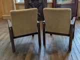 two chairs sitting in front of a fireplace in a room